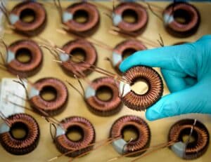 Worker holding Electromagnetic coils in electromagnetics factory, close-up